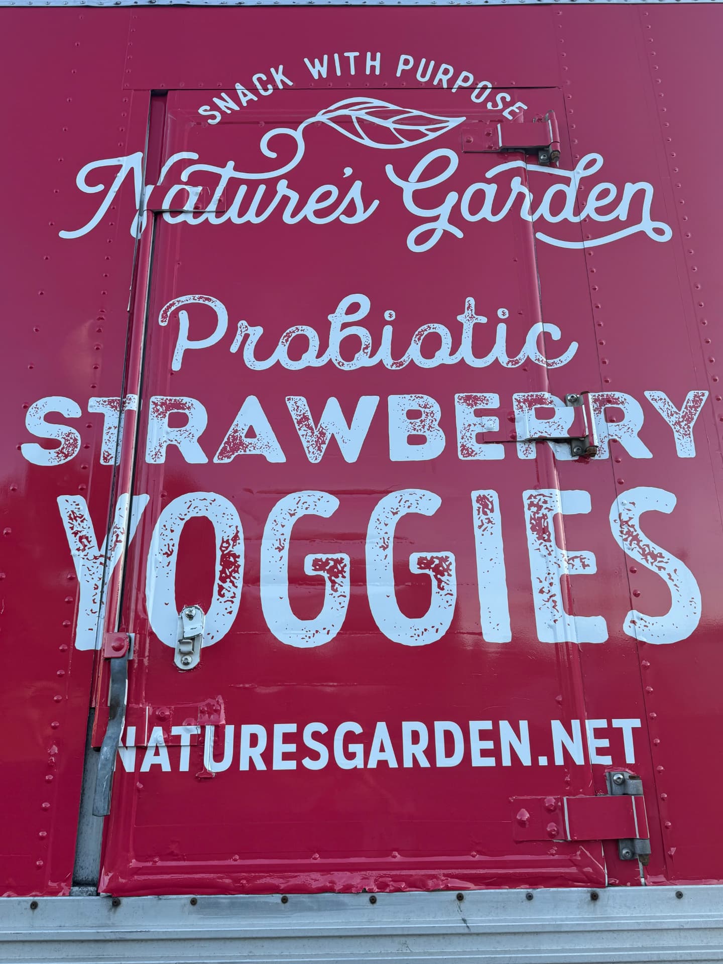 Close-up of a red Nature's Garden box truck wrap with hand-lettered graphics