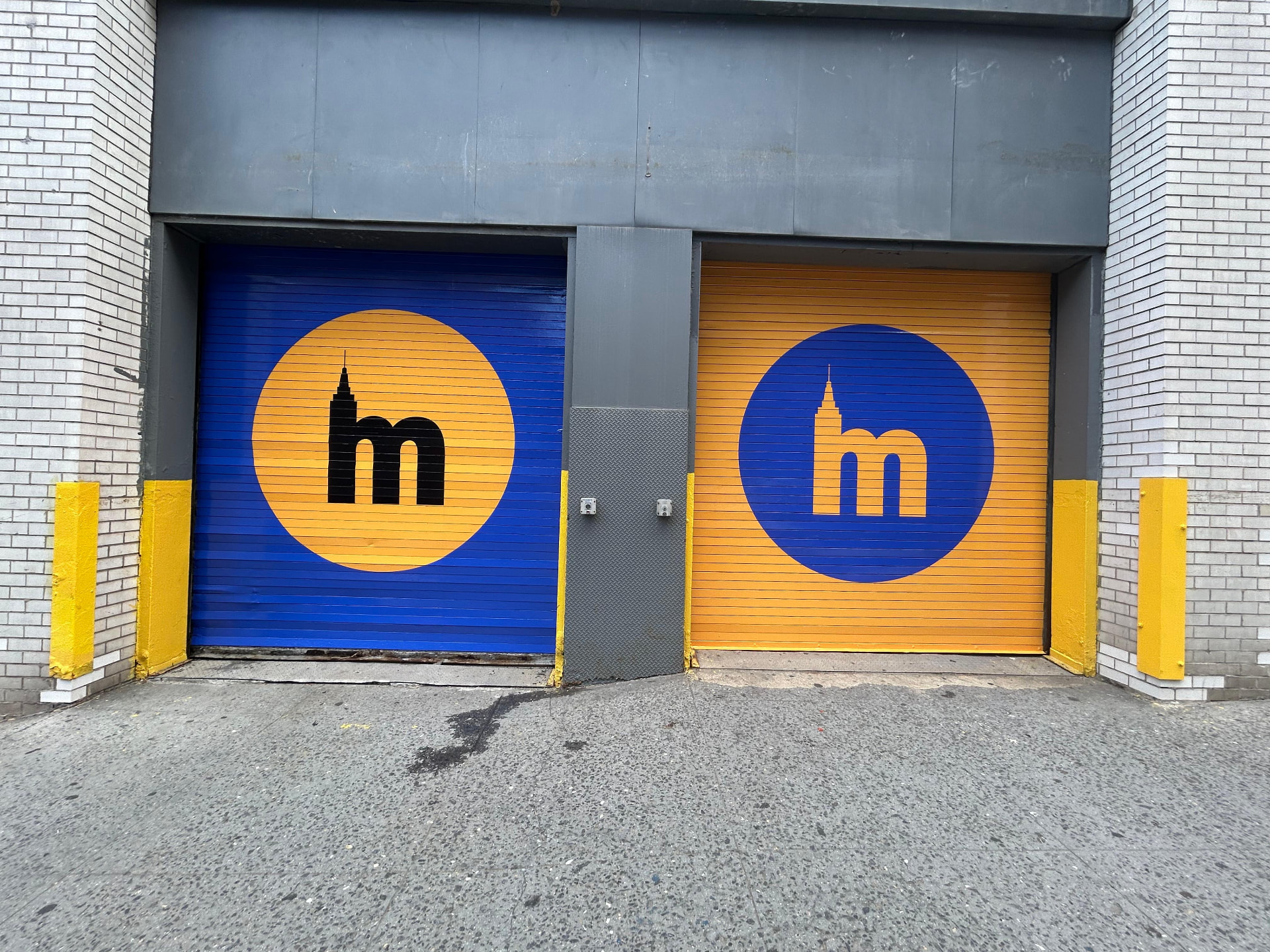 Branded roll-up garage doors with large Metro M logo in blue and yellow