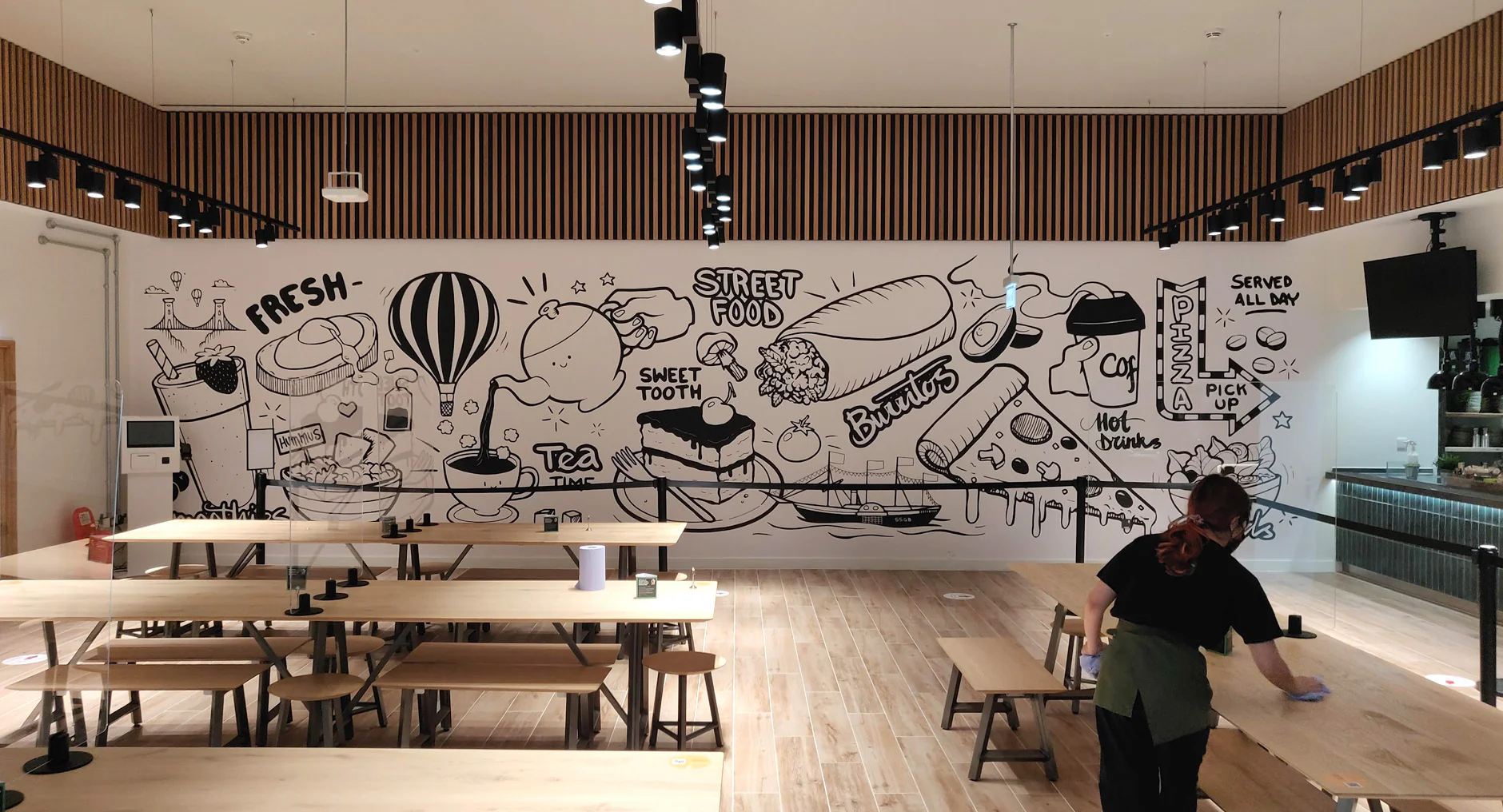 Illustrated black and white printed wall mural inside a cafe