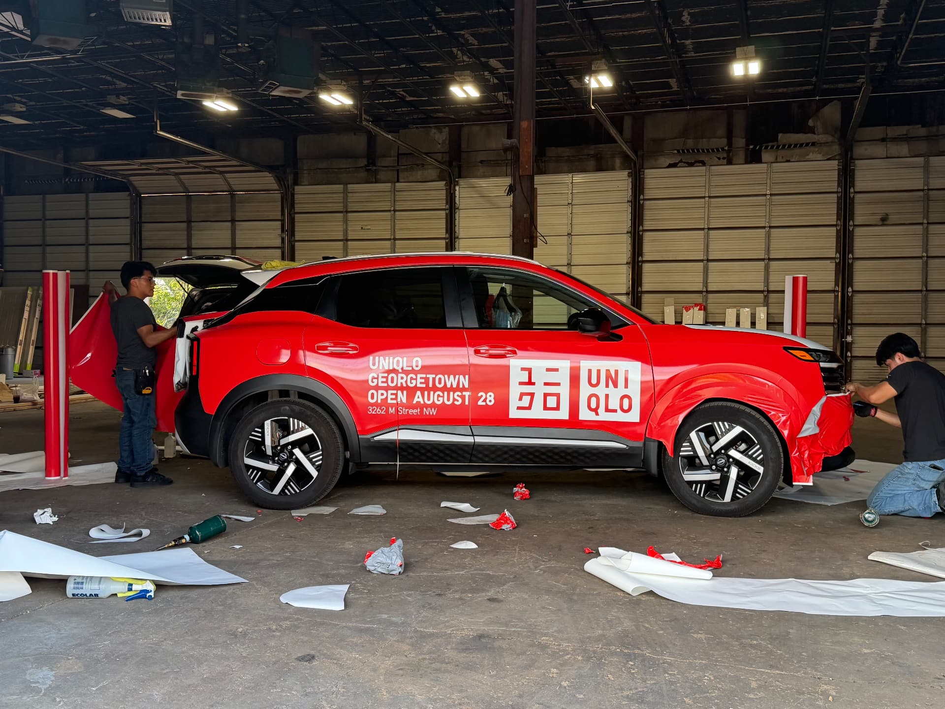 Red UNIQLO Georgetown store opening SUV wrap being installed