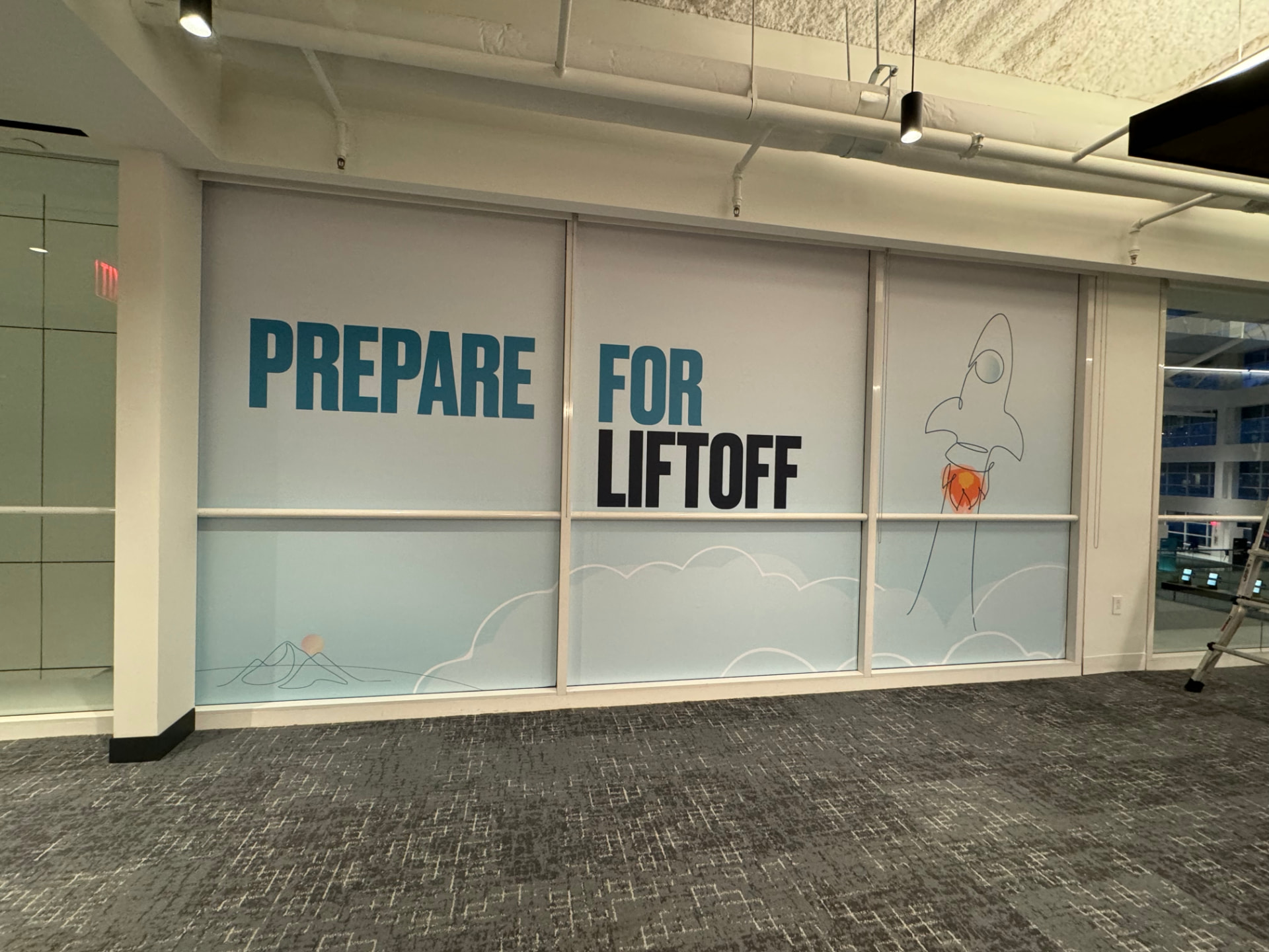 Interior office glass wall with frosted and printed Prepare For Liftoff window graphics