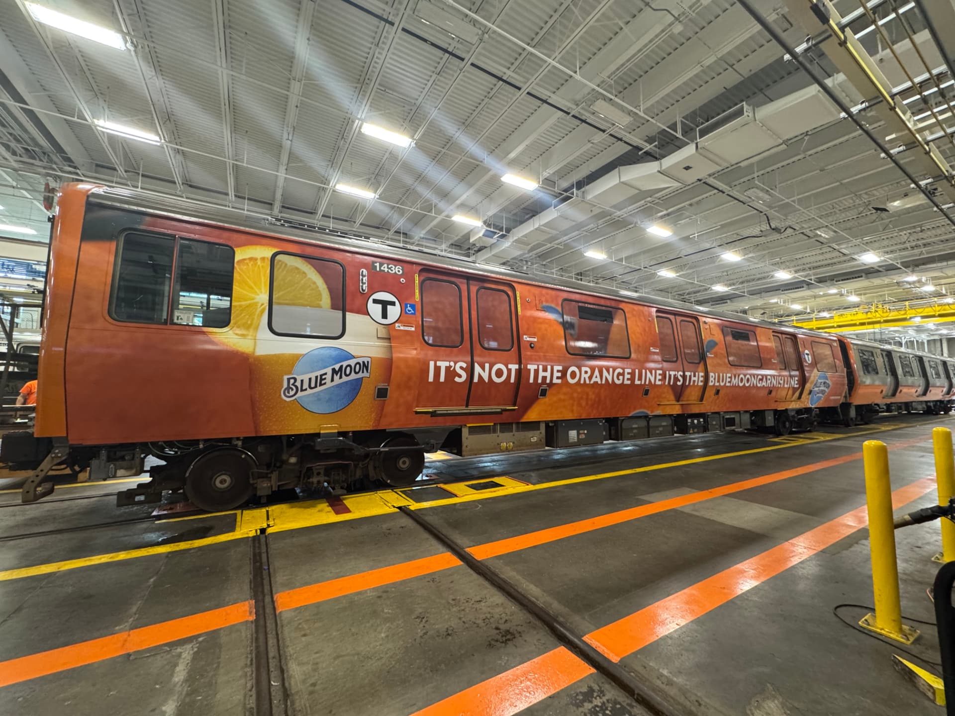 Blue Moon full transit train wrap inside a rail maintenance facility