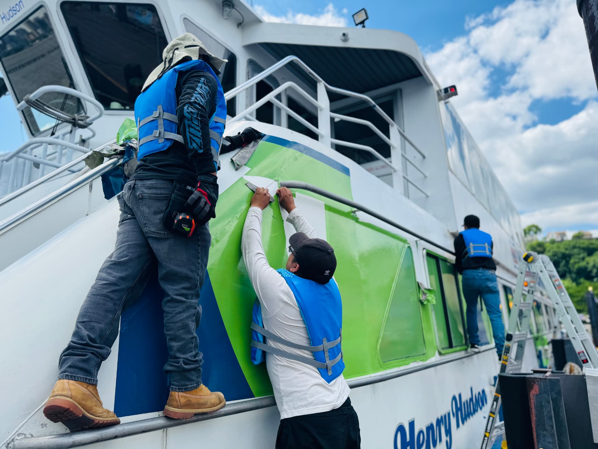 Crew installing vinyl graphics on a passenger ferry