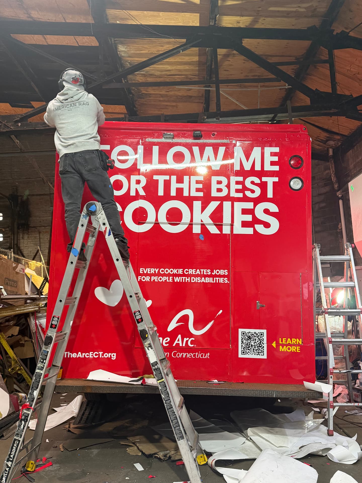 Installer applying a red cookie brand box truck wrap